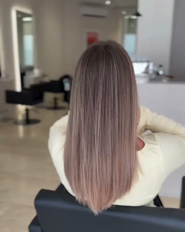 Glatte lange Haare mit kühler Balayage zwischen Blond und Braun.